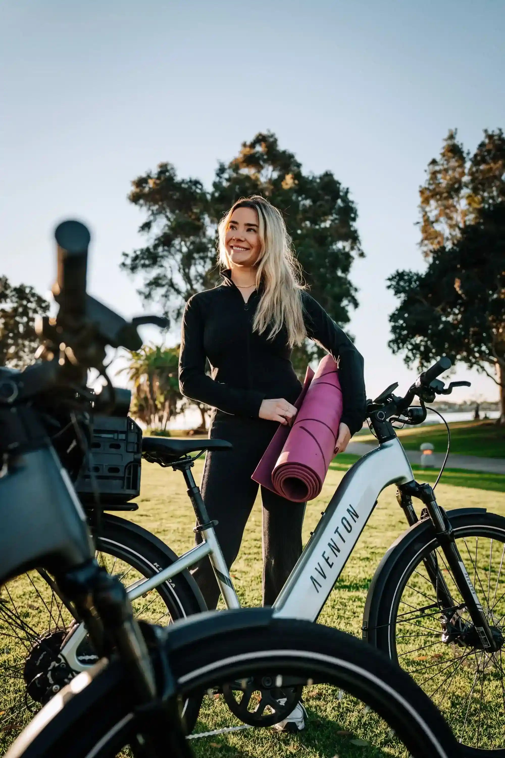 Women standing next to Aventon Level 3 Stepthru City E-Bike in park