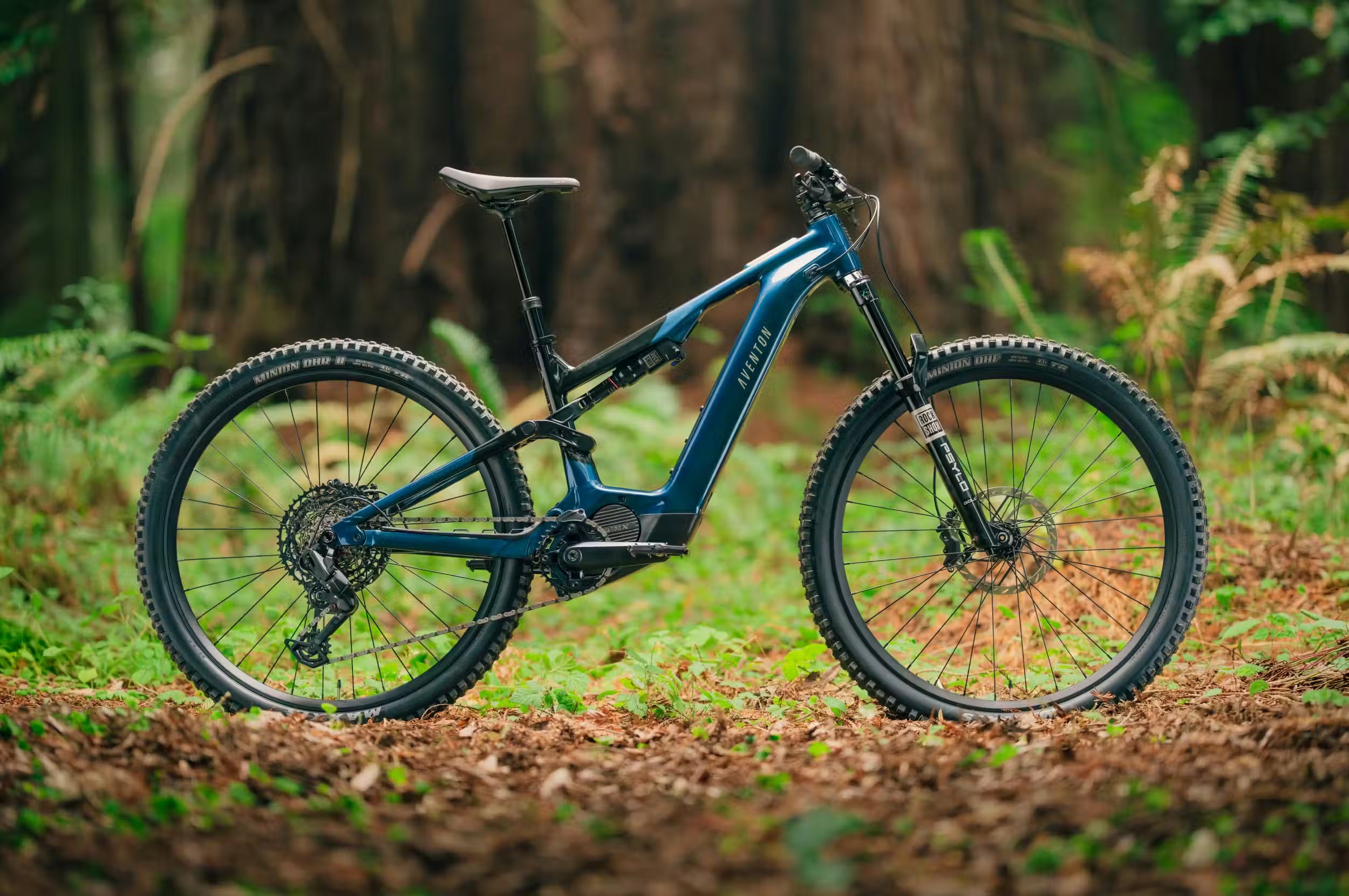 Blue Aventon Current ADV mountain bike on a forest trail