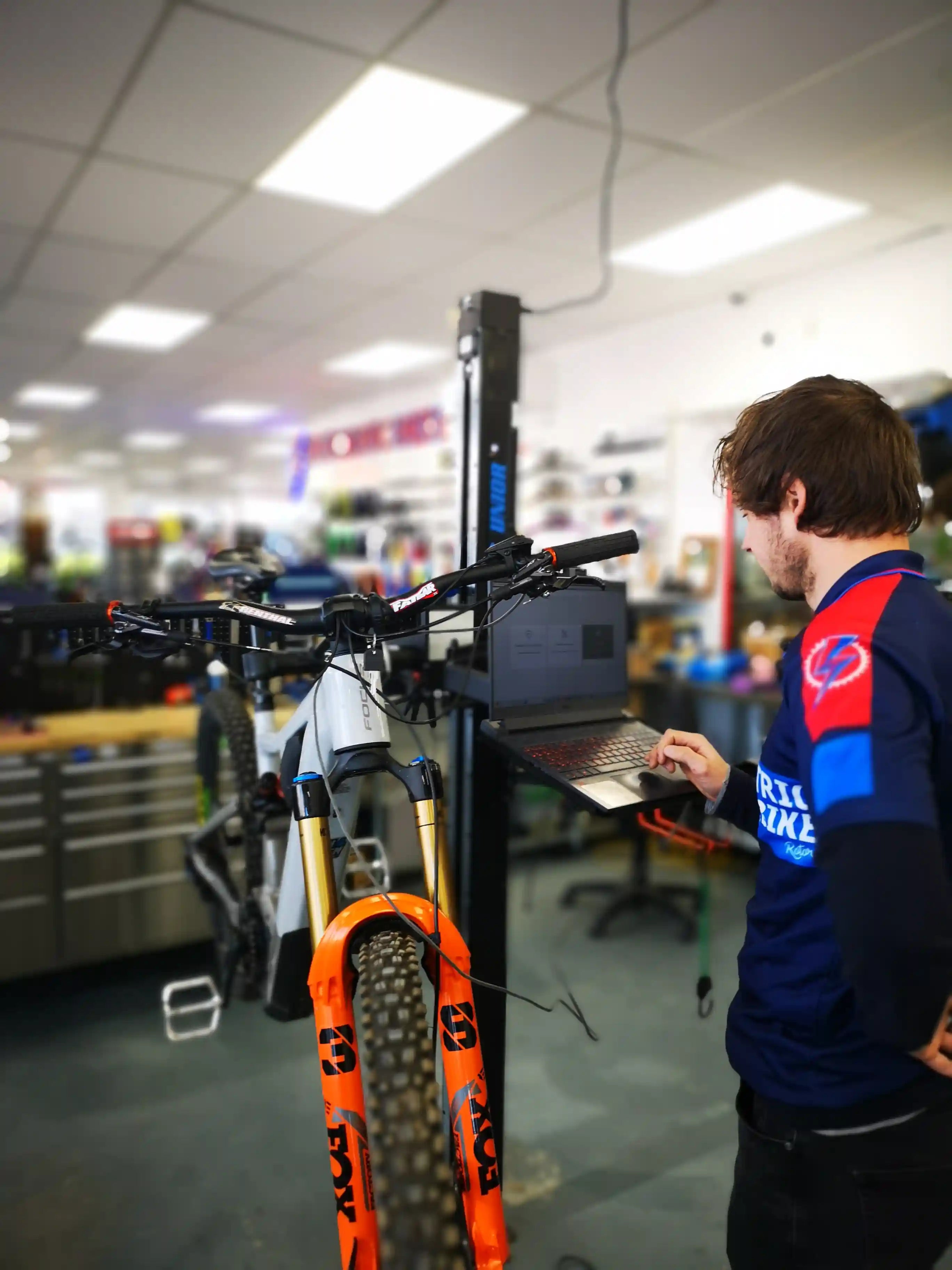 EBR bike mechanic using a laptop on an E-bike in the workshop.
