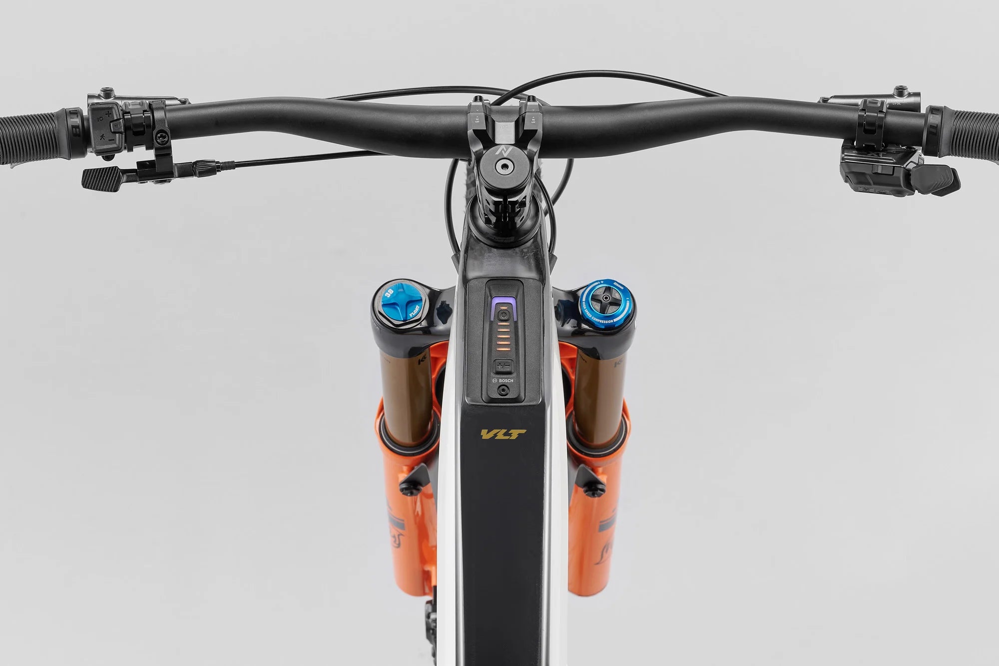Close-up of a bicycle handlebar with VLT suspension forks on a gray background