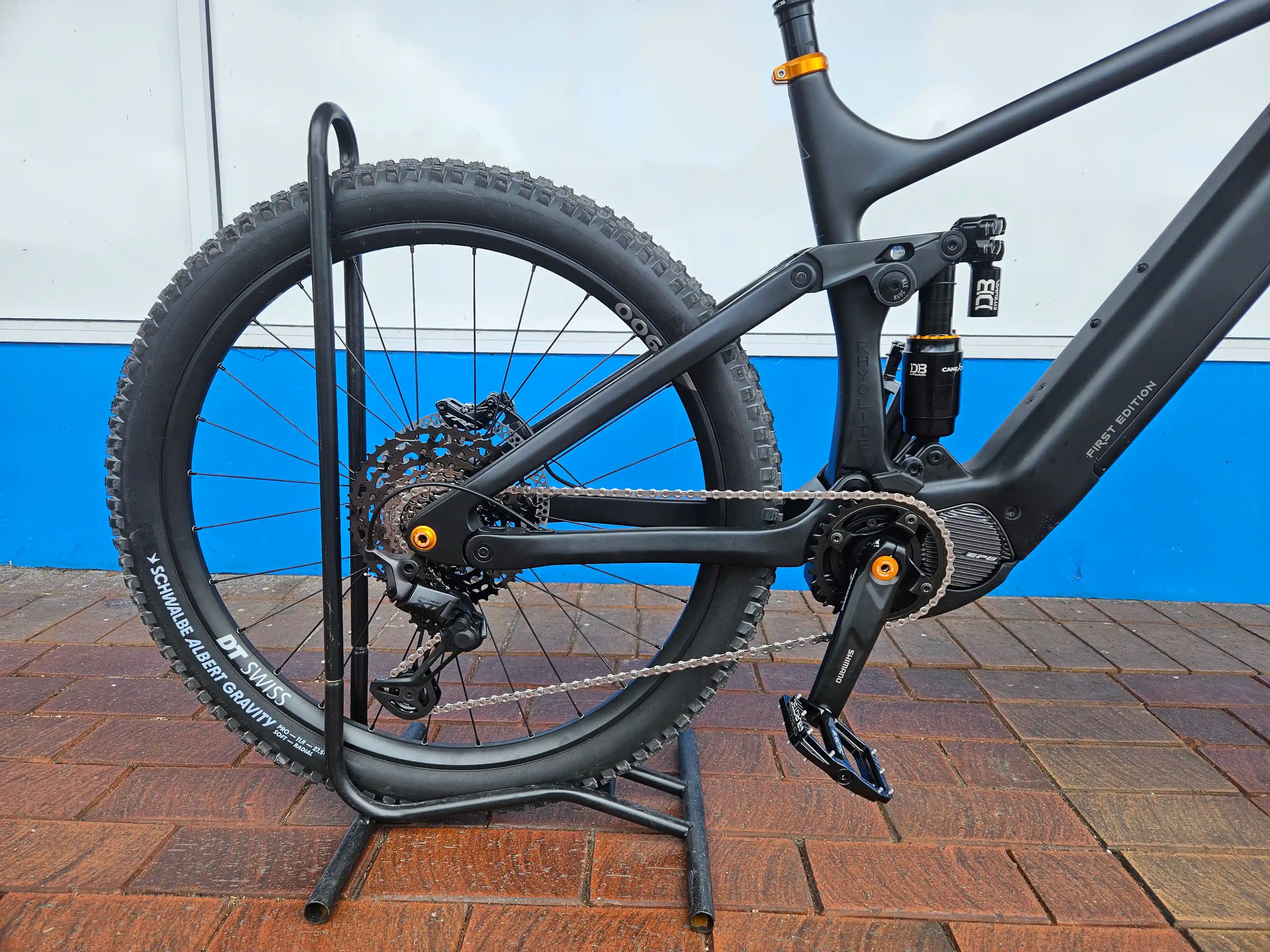 Rhyolite Elite E-MTB on a stand with a blue and white wall in the background
