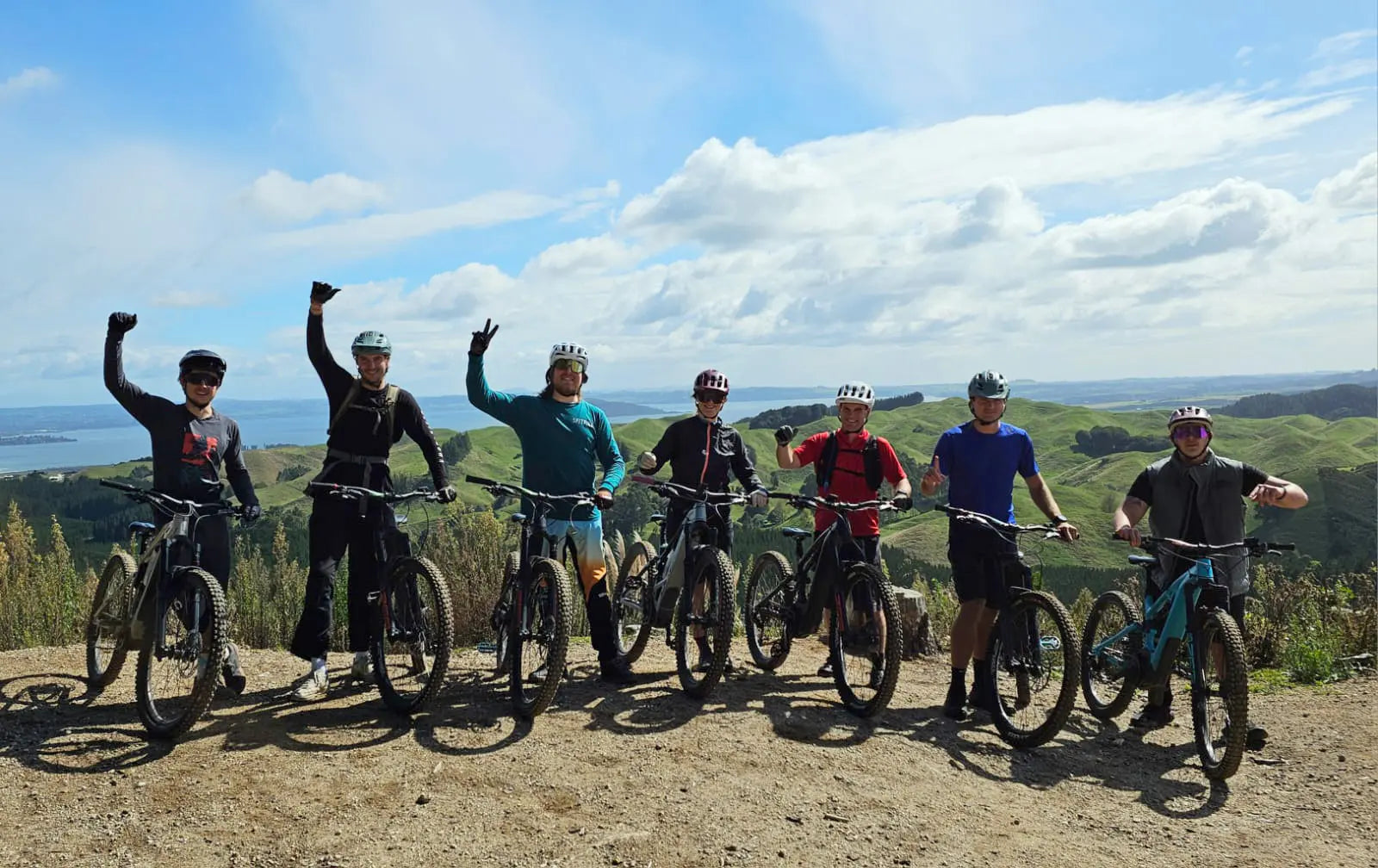 Group of mountain bikers posing on a trail with a scenic background
