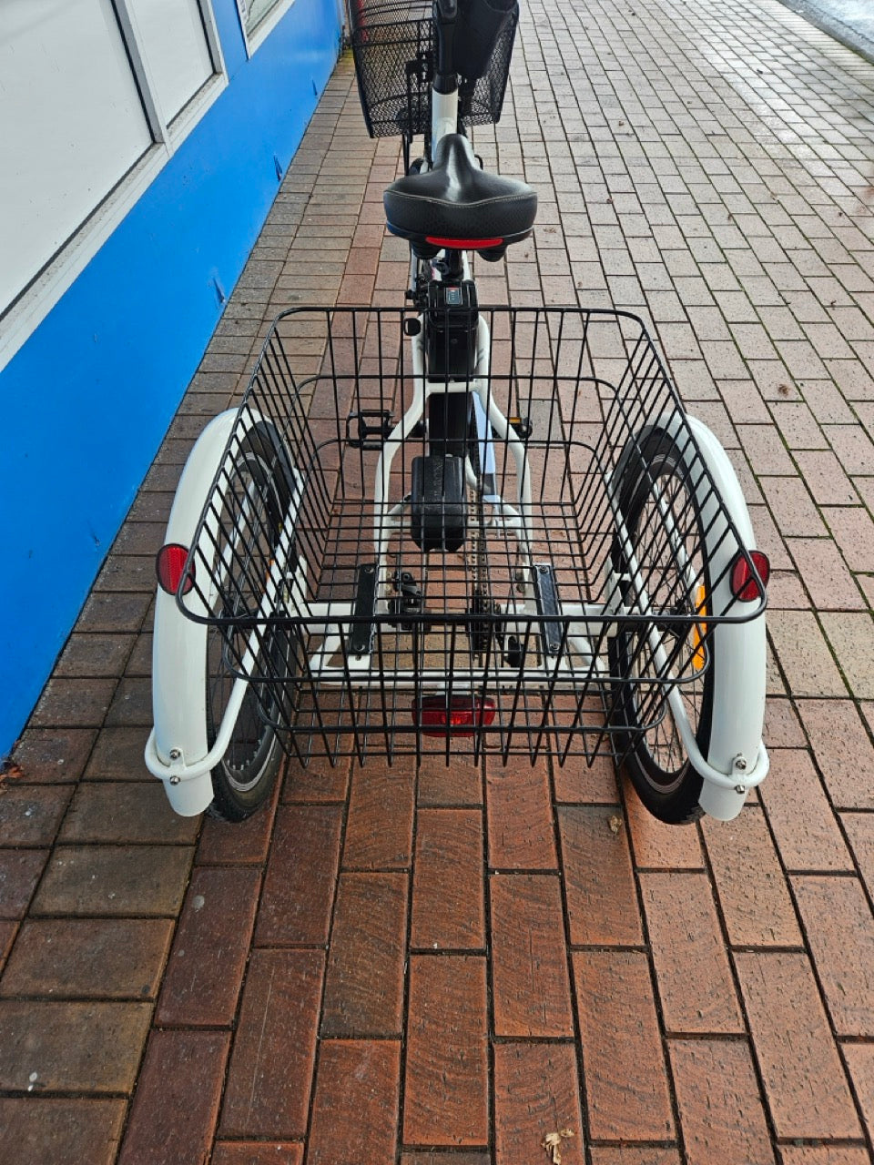 Bicycle with a front basket on a paved sidewalk
