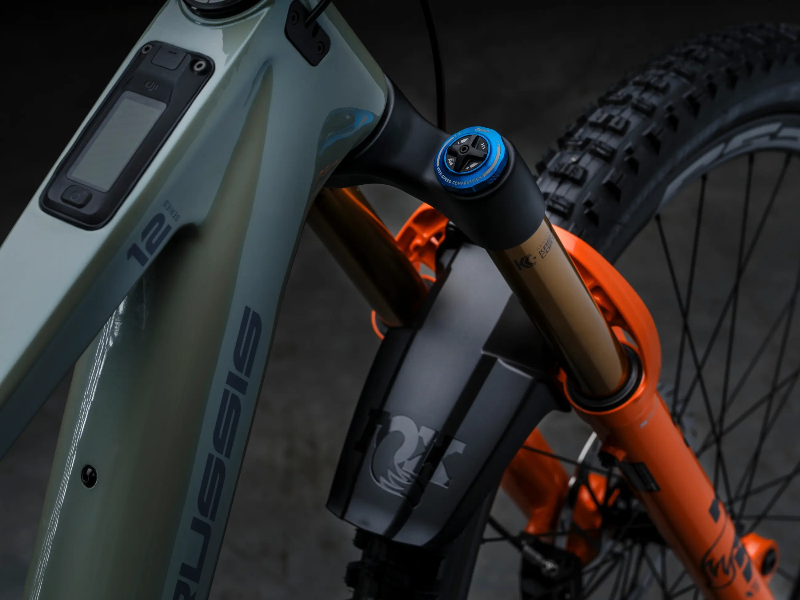 Close-up of aCrussis e-Full 12.11-PRO suspension fork with orange and gray components.