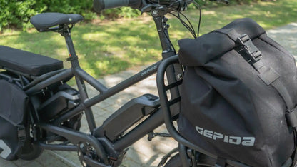Gepida electric bike with storage bags on a blurred outdoor background
