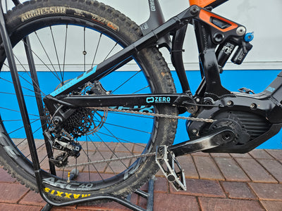 Electric bike with a visible brand logo against a blue wall.