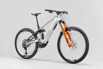 White mountain bike with orange suspension fork on a gray background