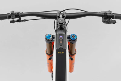 Close-up of a bicycle handlebar with VLT suspension forks on a gray background