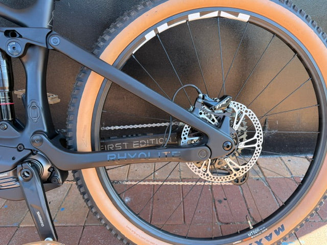 Close-up of a Rhyolite Base+ wheel with disc brake system on a paved surface
