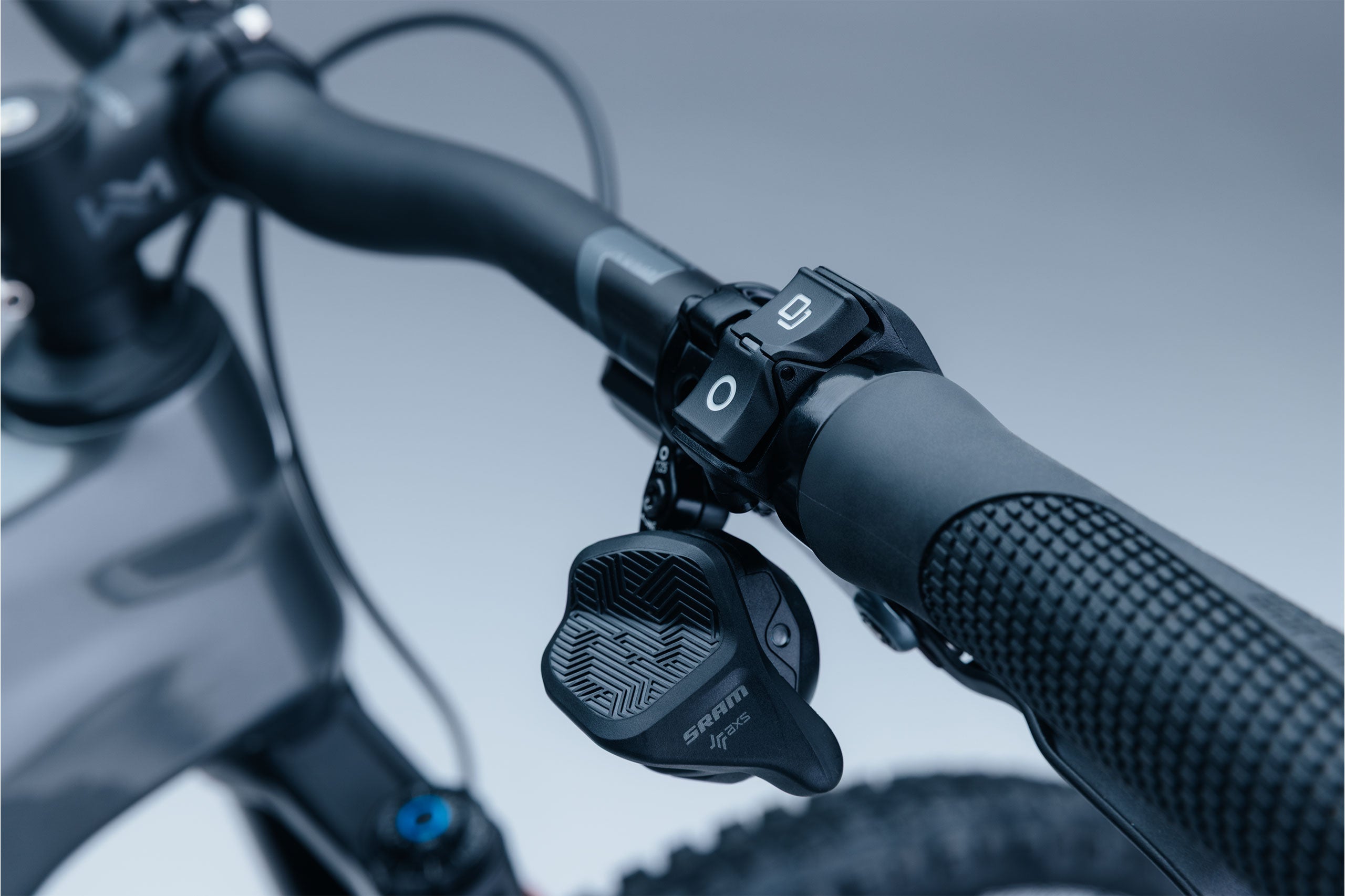 Close-up of a bicycle handlebar with control levers on a blurred background