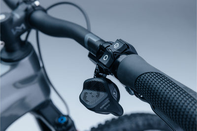 Close-up of a bicycle handlebar with control levers on a blurred background