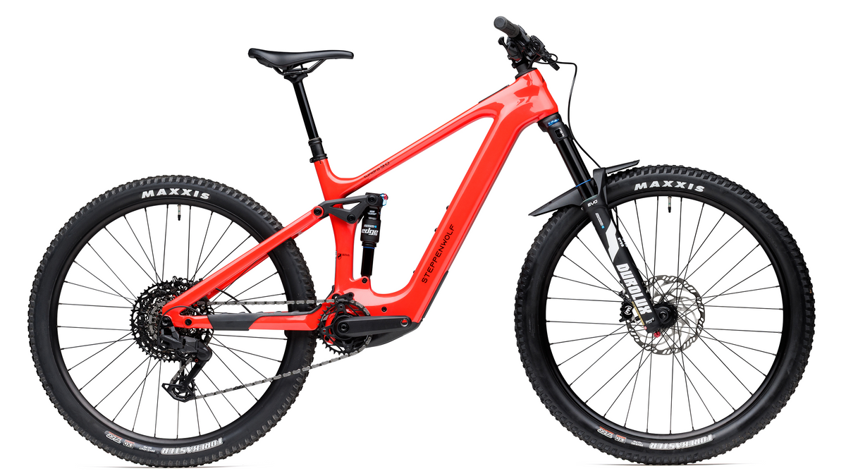 A red Steppenwolf Tundra 9 full-suspension mountain bike with black Maxxis tires, a black seat, and a black front fork, shown from a side profile on a white background.