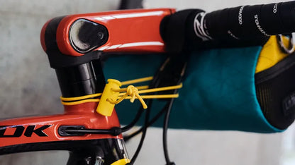 Close-up of a bicycle handlebar with a person wearing gloves and a blue sleeve.