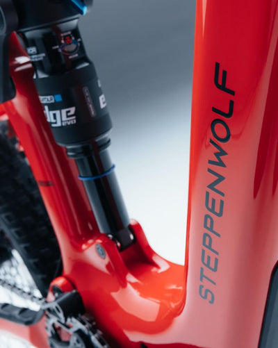Close-up of Steppenwolf Tundra 9 in red mountain bike frame with the brand name STEPPENWOLF printed vertically in dark gray. 