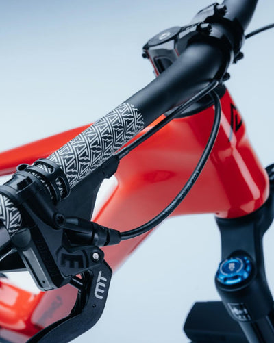 Close-up of a steppenwolf tundra 9 handlebar area showing a bright red frame, black handlebar,  Magura MT black brake lever. 